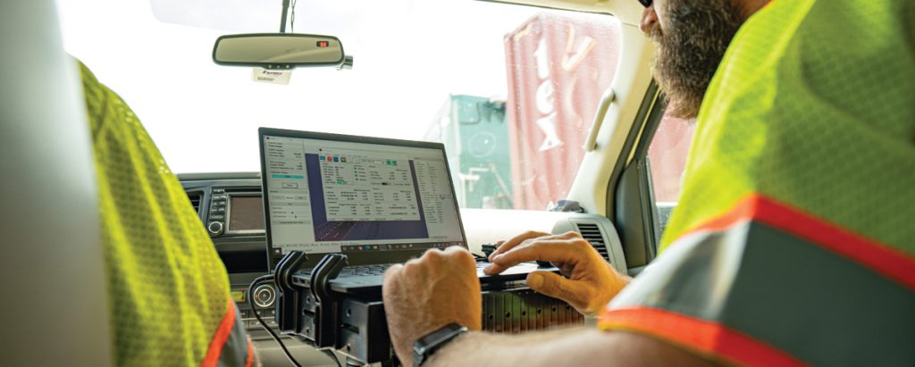 man working on truck laptop