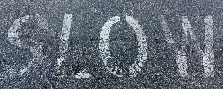 faded slow sign on pavement