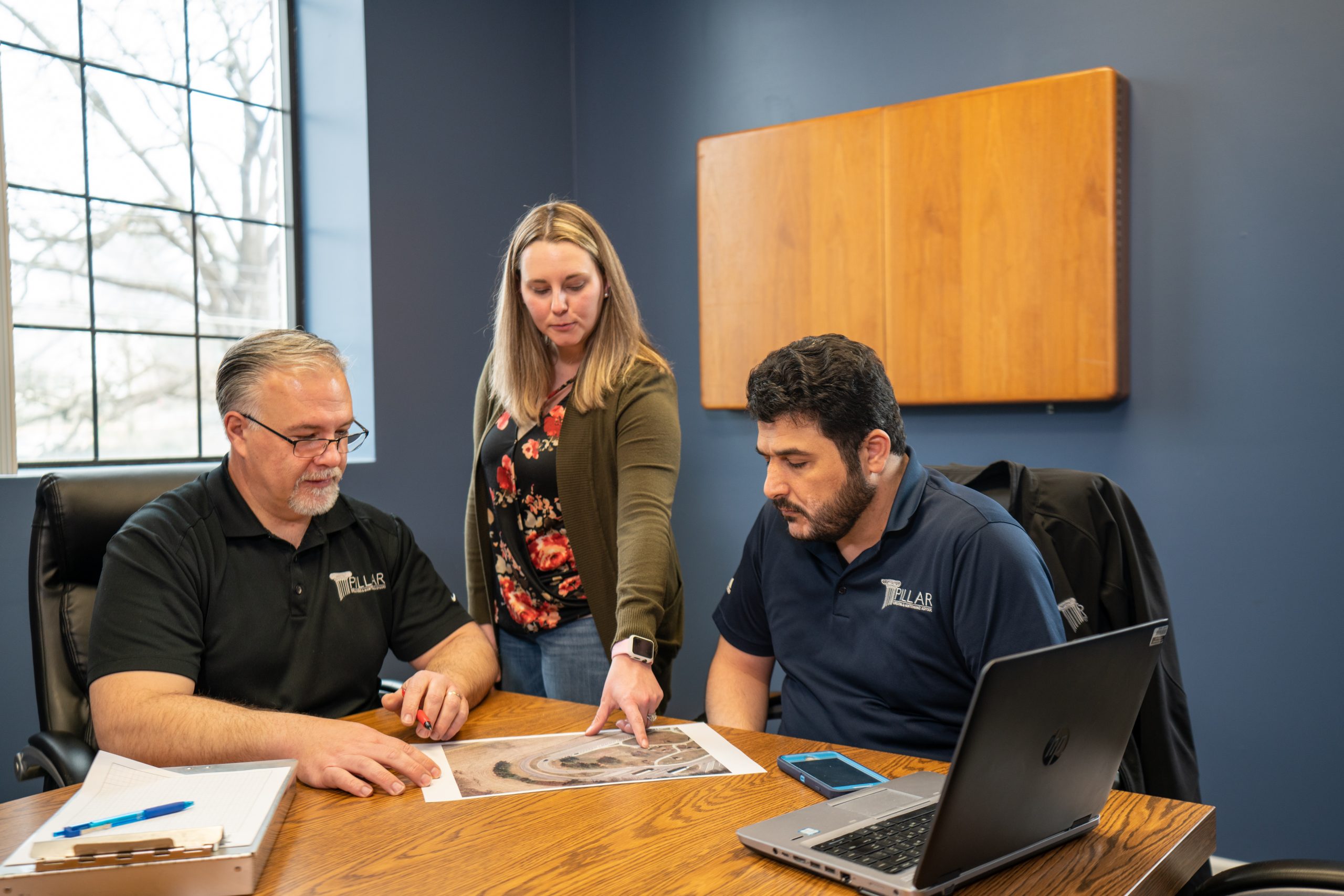three employees reviewing paperwork