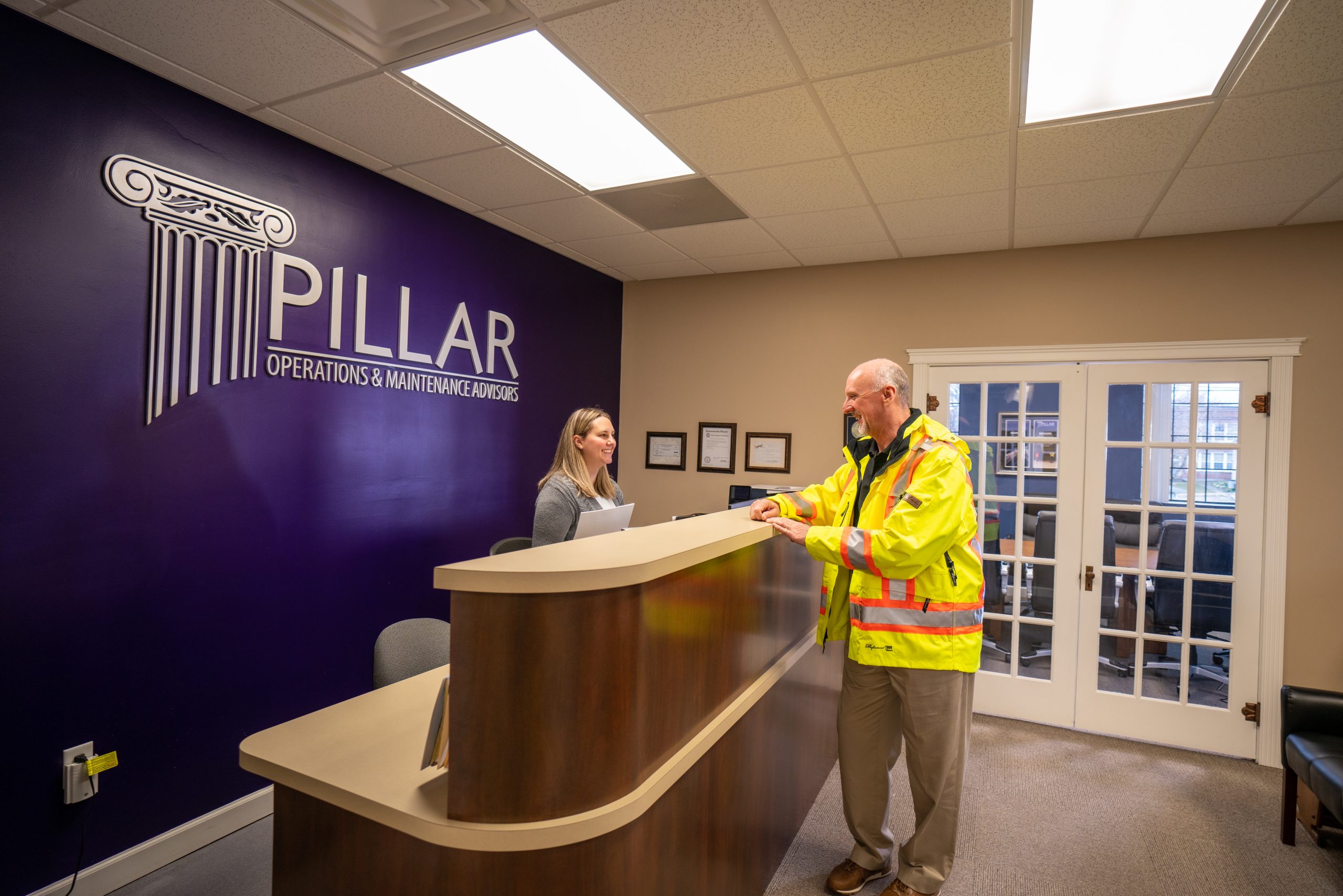 two employees talking at a desk