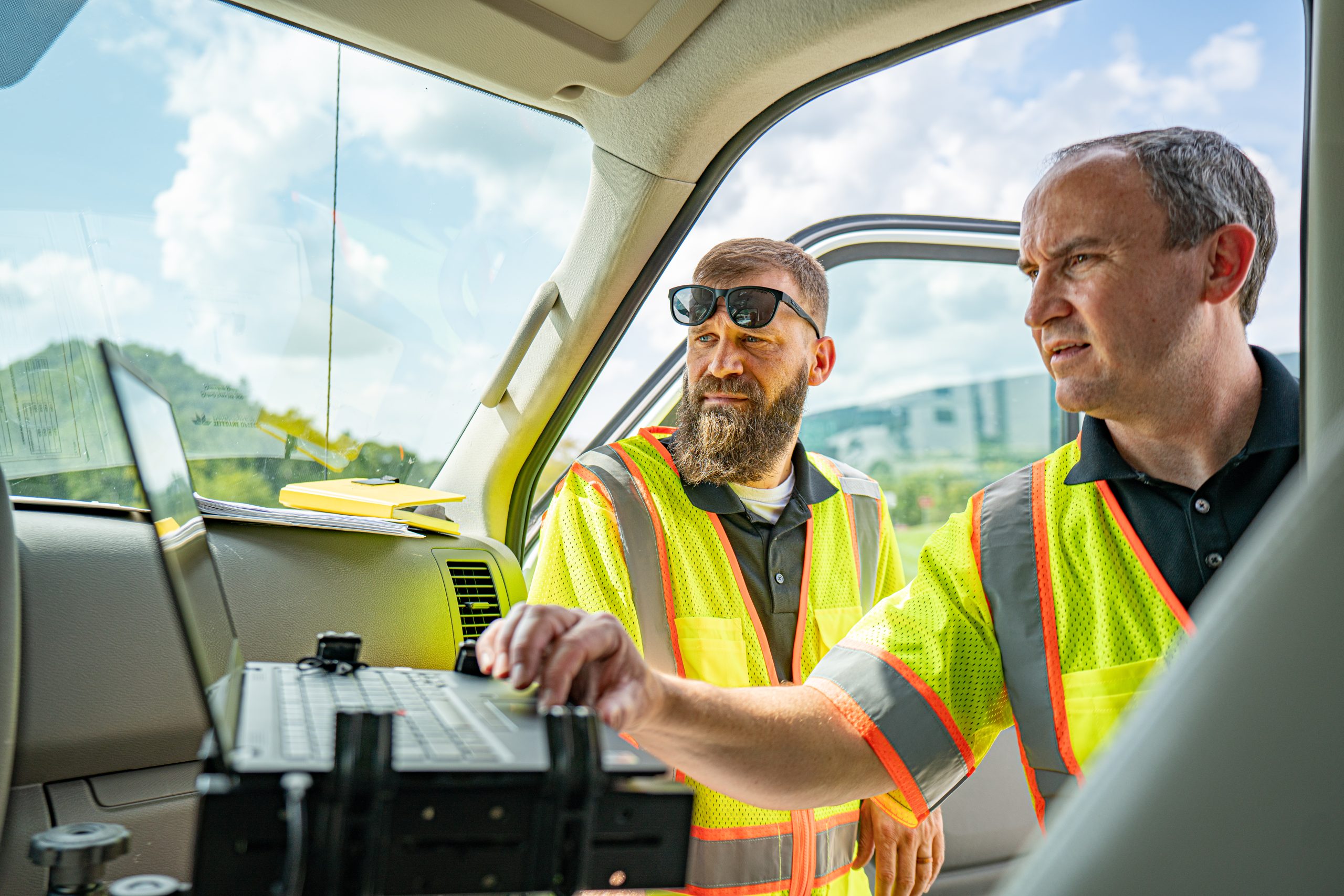 two men working at a computer in a truck