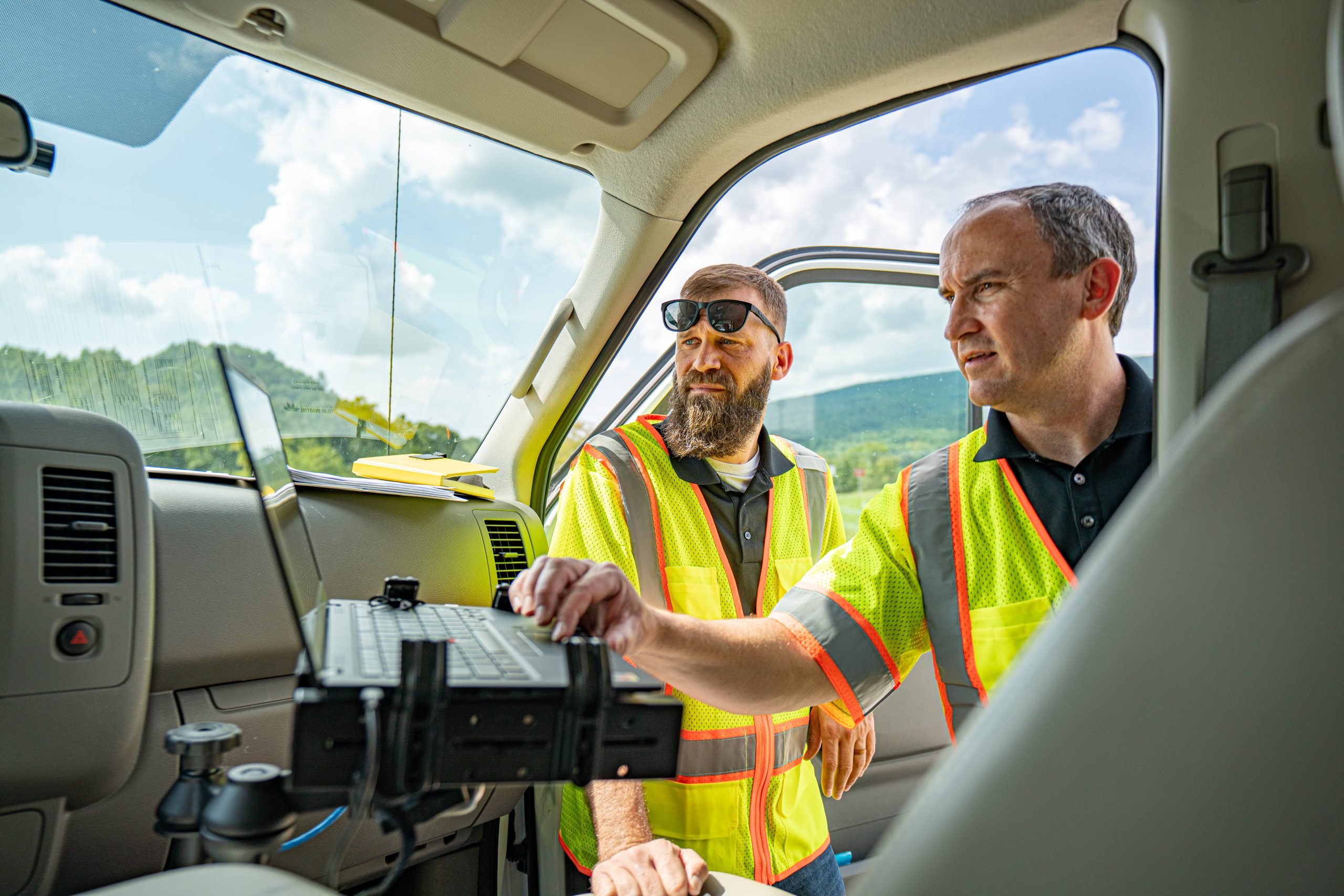 two men at a computer in a truck